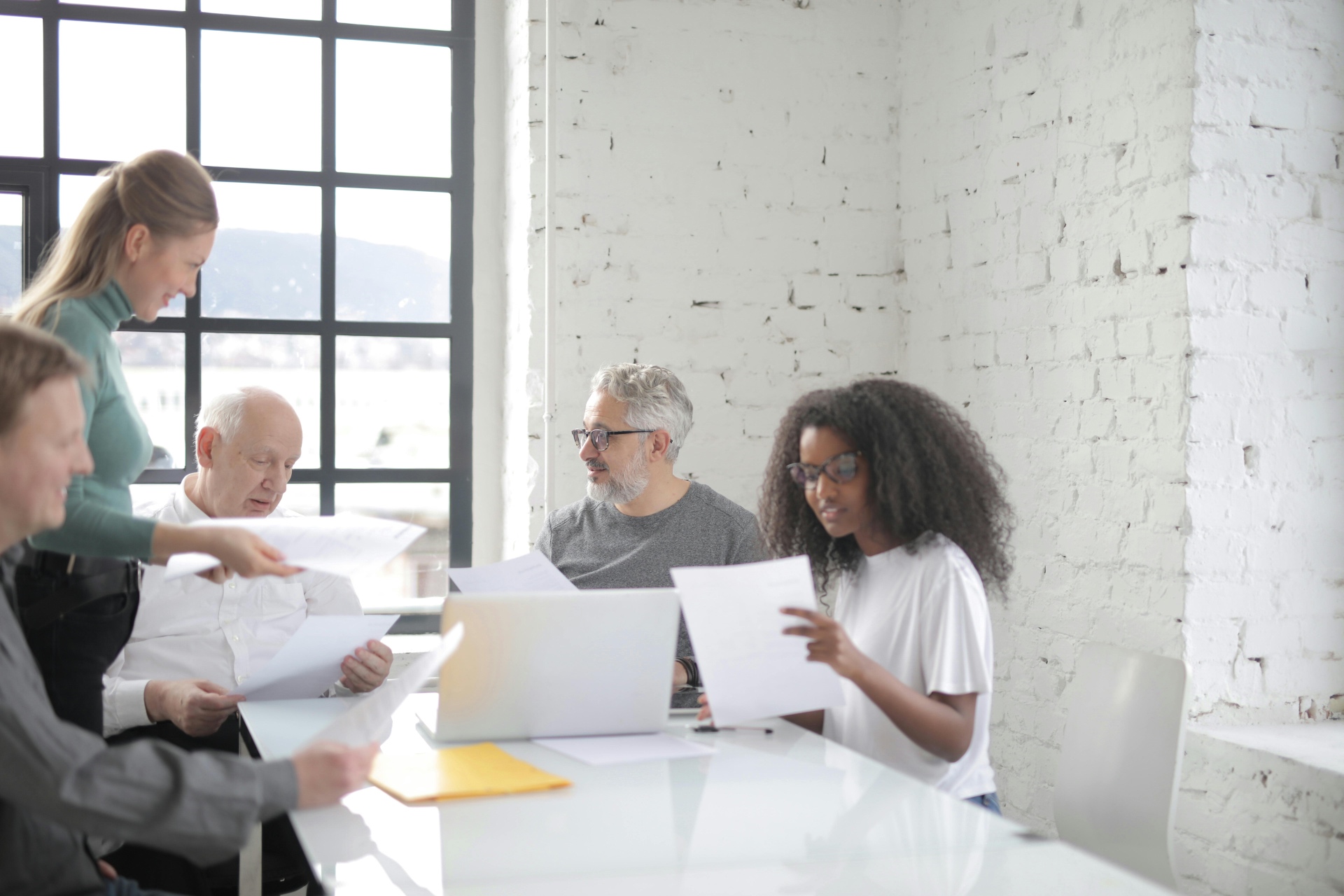 Team reviewing hiring paperwork around a conference table